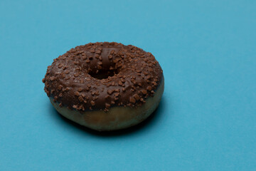 einzelner Schoko Donut auf blauem Untergrund - Single Chocolate donut on a blue background