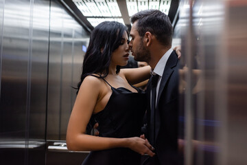 Sexy couple kissing in elevator on blurred foreground