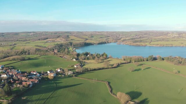 Aerial drone view of blue water lake and surrounding countryside in Blagdon, Somerset, UK