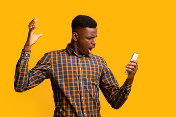 Unexpected Mesage. Emotional Black Guy Looking At Smartphone Screen With Shock