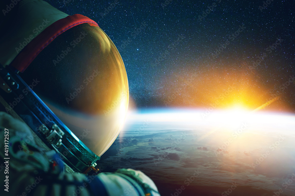 Poster astronaut in a space suit with a helmet in space with the blue planet earth and rays of sunsets. spa