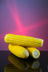 Cooked sweet corn with reflection on glass table