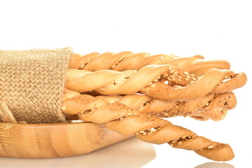 Several delicious grissini bread sticks with a jute cloth napkin, close-up, isolated on white.