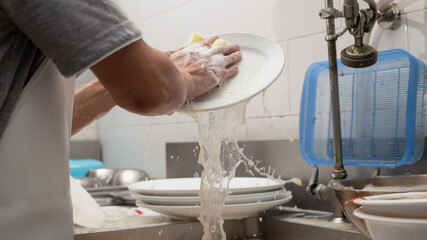 Man washing dish in sink