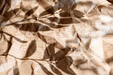 Wrinkled craft paper with hard shadows, for packaging goods and gifts. The background is craft paper, eco style.