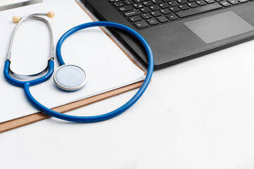 medical review chart next to a stethoscope next to a laptop with copy space. webinar concept.