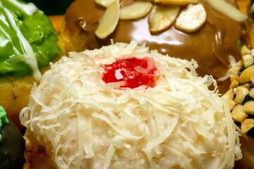 Cheese sprinkled donut and red berry in shallow focus