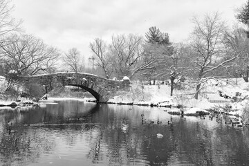 Black and White Photo of the Pond and Old Gapstow Bridge at Central Park in New York City during Winter with Snow and Ice