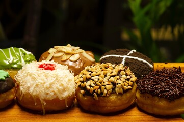 Colorful homemade donuts in shallow focus  with dark background