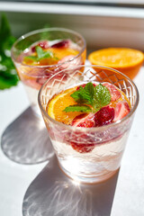 Summer cocktail with strawberry, orange and mint in glass