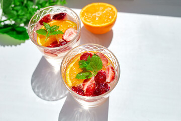 Summer cocktail with strawberry, orange and mint in glass