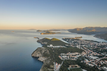Aerial drone shot of Lapad hill in Dubrovnik town with sunrise over the peak in Croatia summer morning