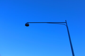 One dark blue lamp post against a bluish sky. Streetlight, lamppost.  Plenty of copy space. Stockholm, Sweden.