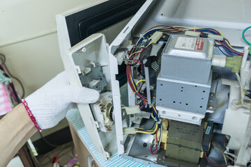 Technician remove microwave timer switch, Checking microwave, Home appliances repair service.