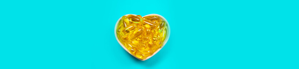 Omega 3 fish oil capsules spilling out of a bottle on a blue background. selective focus.