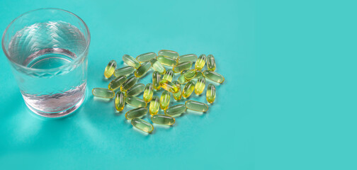 Omega 3 fish oil capsules spilling out of a bottle on a blue background. selective focus.