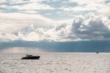 boat sailing in the sea under similar clouds