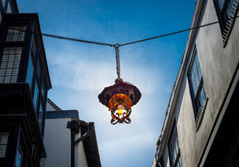Obraz premium Decorative lantern hangs between buildings on Mercery Lane in the historic city of Canterbury, England.