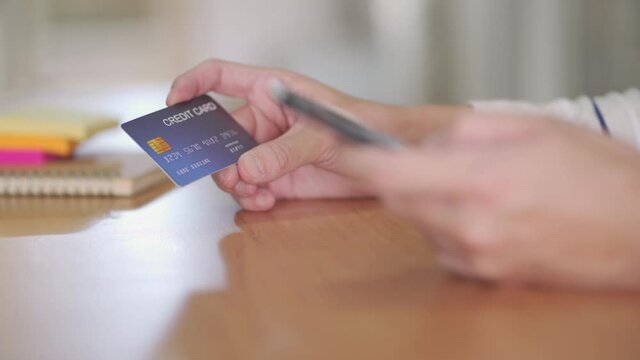 Indoor shot of men hand and smartphone.  While typing credit card mock up number information and CCV security code for online payment transaction. Digital banking with internet communication.