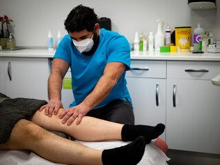 Obraz premium PHYSIOTHERAPIST IN YOUR CLINIC WITH A MASK