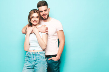 Fototapeta premium Smiling beautiful woman and her handsome boyfriend. Happy cheerful family having tender moments near blue wall in studio.Pure cheerful models hugging.Embracing each other