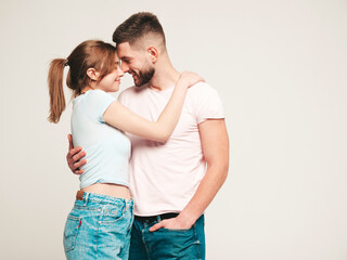 Smiling beautiful woman and her handsome boyfriend. Happy cheerful family having tender moments.Posing on grey background in studio.Pure models hugging.Embracing each other.Love concept