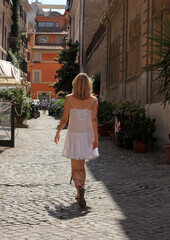 A beautiful girl with her back turned with a model figure harry up forward  around the city of Rome...