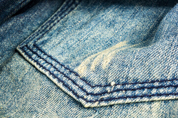 clothing items blue stonewashed faded jeans cotton fabric texture with seams, clasps, buttons and rivets, macro, close-up