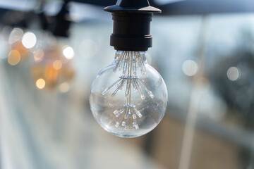 Retro light bulb in outdoor blurry background
