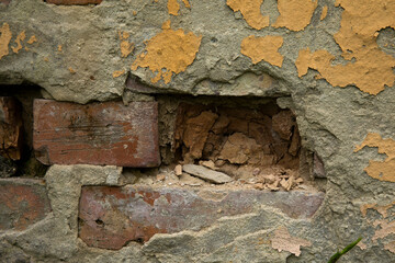 Close up of old damaged brick wall with cracked plaster