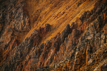 Scenic nature background of multicolor mountain. Colorful nature backdrop of motley rocks. Multicolor great rocks of vivid colors. Beautiful red orange rufous golden rocks. Closeup of motley mountain.