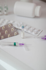 Medications. Ampoule of a medical syringe isolated on a white background. Pills.