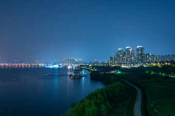 Obraz premium It is a beautiful night view of the city. It's a nice picture, including a river and a promenade through which the boat passes.