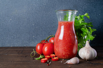 Tomato sauce with red chili in a glass jar on a wooden table