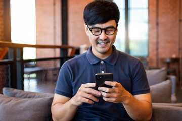 Fototapeta premium asian man work using cell phone hand holding mobile texting message contact us.chatting,search internet information in office.technology device communication connecting