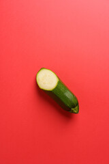 fresh green half zucchini on a red background. Food concept. Copy space
