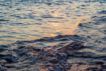 pebble stones on the sea beach, the rolling waves of the sea with foam