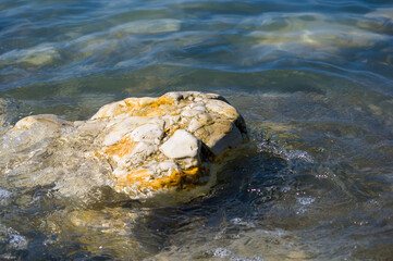 pebble stones on the sea beach, the rolling waves of the sea with foam