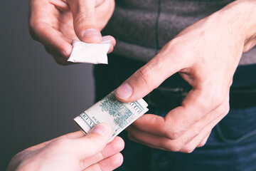 closeup of a drug addict with money buying a dose