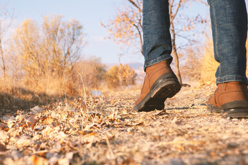 Legs of a man walking outdoors. Lifestyle fashion trendy style autumn season nature on background.