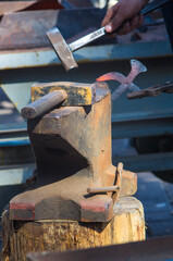 blacksmith performs the forging of hot glowing metal on the anvil