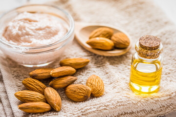cosmetic set with almond scrub on table background