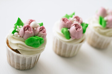 Tender cake with whipped cream. Cake in the form of flowers. Cupcake with whipped cream.