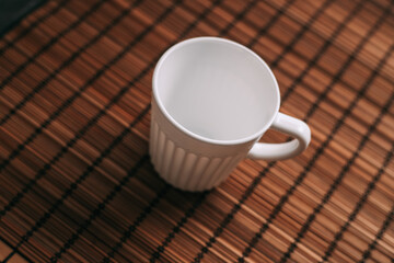 white mug on a wooden stand stands on the table top view