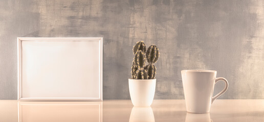 Modèle de cadre photo blanc avec espace vide pour logos, inscription publicitaire. Cadre en mode paysage sur un espace de travail avec une tasse. Ambiance zen.