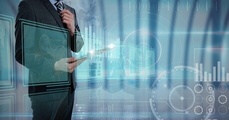 Digital interface with data processing against mid section of businessman using digital tablet