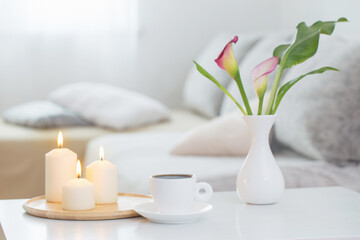 Fototapeta na wymiar cup of coffee and flowers in vase on white table indoor