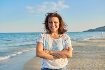Fototapeta na wymiar Portrait of happy smiling confident middle aged woman on beach