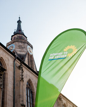 Flagge der politischen Partei B&uuml;ndnis 90 Die Gr&uuml;nen vor einer Kirche in T&uuml;bingen, Deutschland