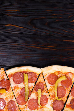slice of pizza paperoni on wood background with copy space